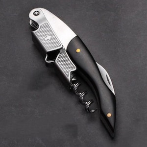 a knife with a black handle on a black surface