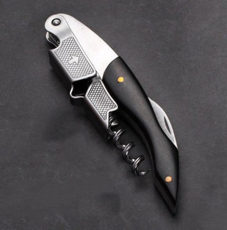 a knife with a black handle on a black surface