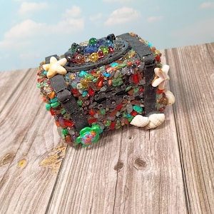 ¡Tesoro enterrado bajo el agua! Caja de madera con bisagras y cierre, cubierta de auténticos cristales, estrella de mar y tortuga de cristal, y conchas reales. Hecha a mano, pieza única.