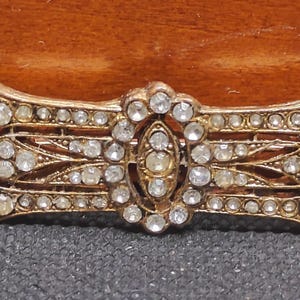Vintage Rhinestones in a Gold Plated Setting Brooch/Pin. (Unsigned). Considering its age, its in good shape. Looks like it&#39;s pretty old.