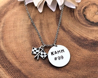 May include: Silver necklace with a round pendant that says "KAMM #99" and a small chequered flag charm.