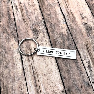 May include: Silver keyring with a rectangular tag that reads "I LOVE YOU DAD".