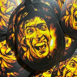 May include: A stack of round stickers featuring a detailed illustration of a screaming face with yellow and orange tones. The face is set against a black background. The stickers have the text "@edwardspumpkins" on them.