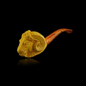 May include: A yellow ram's head pipe with a brown wooden stem. The pipe is carved in the shape of a ram's head with detailed features.