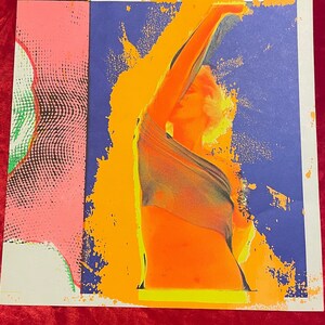 May include: A colorful abstract art print featuring a figure in a yellow, orange, and green color scheme against a blue background.