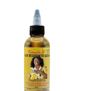 May include: A clear bottle of "Formula D" Hair Regrowth Serum. The label features a woman's image and the text "Eden Kingdom Essential" with the claim "Makes Hair Visibly Thicker, Longer, & Stronger!" The bottle contains a yellow liquid and has a black cap.