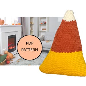 May include: A triangular crochet pillow shaped like a candy corn with a white top, orange middle, and yellow base. A circular overlay on the left side contains the text PDF PATTERN. The background shows a fireplace and a living room setting.