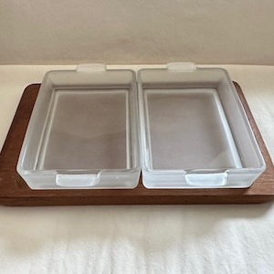 May include: A wooden serving tray with two clear glass dishes. The dishes have rounded edges and are slightly frosted.