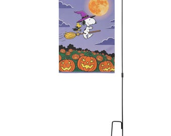 May include: A rectangular garden flag featuring a cartoon dog wearing a purple witch hat, riding a broomstick with a small yellow bird. The background shows a full moon in a purple sky with clouds above a field of orange jack-o'-lantern pumpkins.