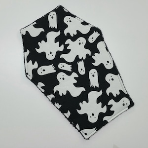 May include: Black and white fabric with a pattern of ghosts. The fabric is sewn into a hexagon shape.