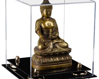May include: A gold-colored Buddha statue sitting on a black base inside a clear acrylic cube display case.