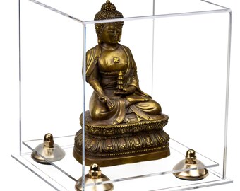 May include: A gold-colored Buddha statue sitting in a clear acrylic display case with a square base. The case has four gold-colored feet.