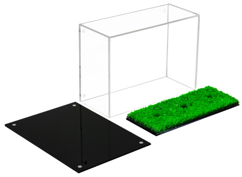 Op de afbeelding: Een transparante acryl vitrine met een zwarte basis en een groene kunstgras basis met drie gaten. De vitrine is ontworpen om kleine items te presenteren, zoals beeldjes of verzamelobjecten.