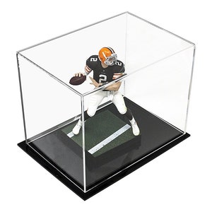 May include: A clear acrylic display case containing a football player figurine wearing a black jersey with the number 2, white pants, and an orange helmet. The figurine stands on a green turf base with a white yard line inside the rectangular case.
