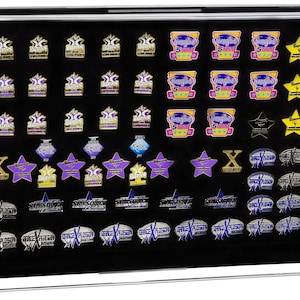 May include: A collection of decorative pins in a clear display case. The pins feature various shapes, including stars, and logos with text. Colors include gold, purple, blue, and pink. The pins are arranged on a black background.