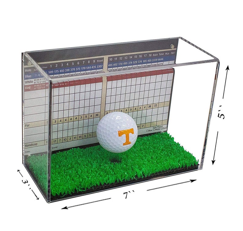 Op de afbeelding: Een transparante acryl display met een golfbal met het logo van de Tennessee Volunteers. De display is 17,8 cm breed, 7,6 cm diep en 12,7 cm hoog. De display bevat een groene kunstgrasbasis en een scorekaart.