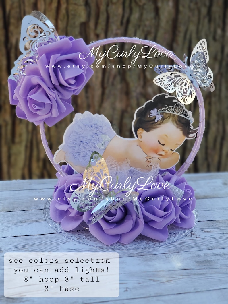 Pode incluir: Um centro de mesa circular com rosas de espuma roxas, recortes de borboletas prateadas e uma ilustra&ccedil;&atilde;o central de um beb&eacute; com tiara e cuecas com folhos. O texto diz MyCurlyLove e inclui um aro de 20,3 cm, 20,3 cm de altura e base.