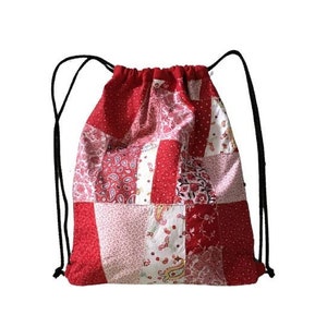 Può includere: Borsa a cordoncino in patchwork rosso e bianco con cordoncini neri.