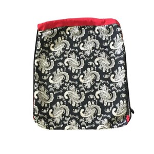 以下が含まれることがあります： 白のペイズリー柄と上部に赤いトリムが付いた黒い巾着袋