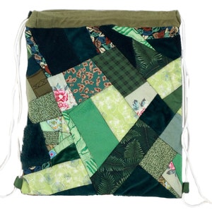 May include: A green patchwork drawstring bag made from various fabrics. The bag is made of different shades of green and has a floral pattern.