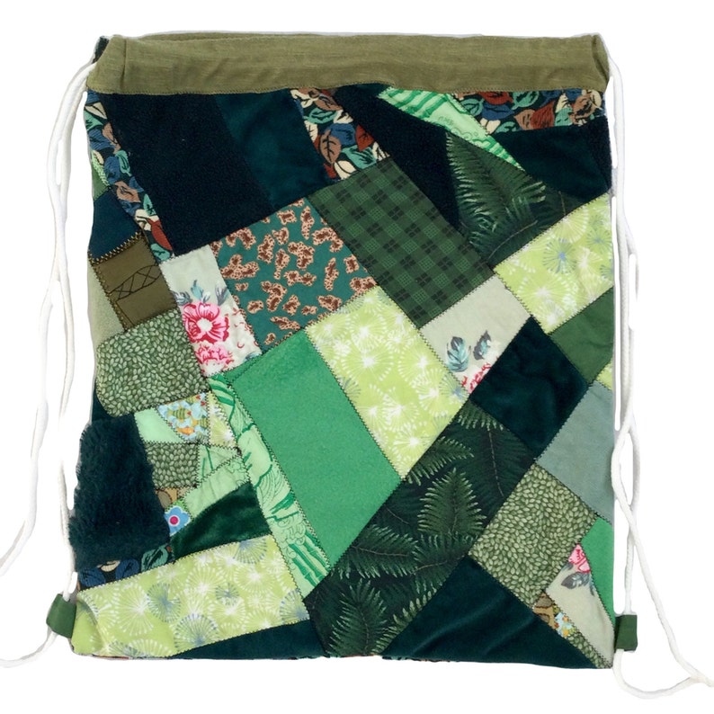 May include: A green patchwork drawstring bag made from various fabrics. The bag is made of different shades of green and has a floral pattern.