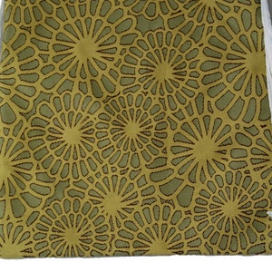 Op de afbeelding: Een groene trekkoordtas met een herhalend patroon van bruine, ronde ontwerpen.