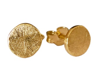 May include: A pair of gold-toned stud earrings with a textured circular design.