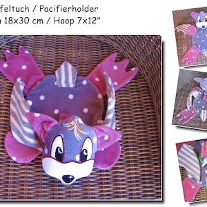 May include: A gray and pink pacifier holder with a cute animal face. The holder is made of soft fabric and has a striped pattern. It is 7 inches by 12 inches.