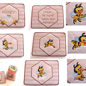 May include: Set of 10 embroidered beige kitchen mats with a bee and honey pot design. Some mats feature the text "Honey" and others feature the text "Erst stirbt die Biene dann der Mensch".