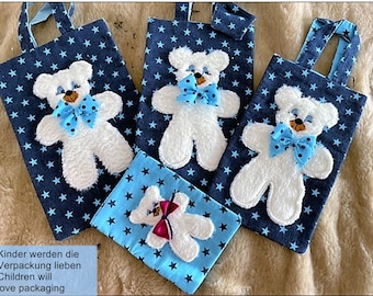 May include: Three blue and white fabric gift bags with white teddy bear appliques and blue bow accents. The bags have blue star patterns and are perfect for gift giving.