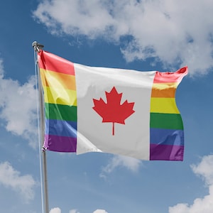 May include: A Canadian flag with a rainbow pride flag design on the left and right sides. The flag is flying in the wind against a blue sky with white clouds.