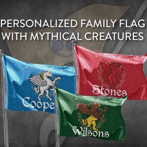 Op de afbeelding: Drie gepersonaliseerde familievlaggen met mythische wezens. De vlaggen zijn blauw, rood en groen. De blauwe vlag heeft een wit pegasushengst met de tekst "Huis van Cooper". De rode vlag heeft een rode draak met de tekst "Huis van Stones". De groene vlag heeft een gouden griffioen met de tekst "Huis van Wilsons".