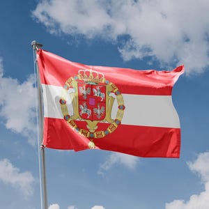 Könnte beinhalten: Eine rot-weiß-goldene Flagge mit einem Wappen, das eine Krone und verschiedene Symbole zeigt. Die Flagge weht im Wind vor einem blauen Himmel mit weißen Wolken.