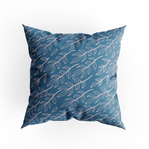 May include: A blue throw pillow with a pink floral pattern. The pillow is made of a soft, comfortable fabric and has a subtle sheen.