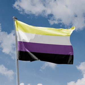 Può includere: Una bandiera gialla, bianca, viola e nera che sventola al vento contro un cielo blu con nuvole bianche.