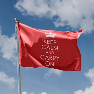 May include: A red flag with the text "Keep Calm and Carry On" in white lettering. The flag is flying in the wind against a blue sky with white clouds.