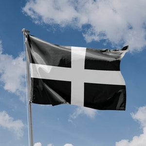 May include: A black and white flag with a white cross, waving in the wind against a blue sky with white clouds.