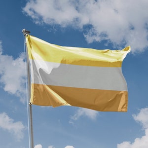 Könnte beinhalten: Eine gelbe, weiße und goldene Flagge weht im Wind vor einem blauen Himmel mit weißen Wolken.