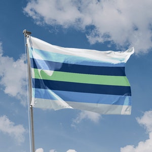 May include: A flag with horizontal stripes of white, light blue, green, and navy blue, waving in the wind against a blue sky with fluffy white clouds. The flag is attached to a silver pole. A "Made in European Union" emblem is in the lower left corner.