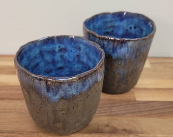 par de tazas de té de gres glaseadas en marrón y azul. hermoso y funcional- sí, está bien beber de estos. Lavaplatos.