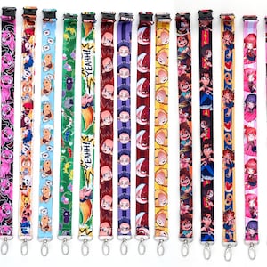 Puede incluir: Una colección de coloridas correas para el cuello con varios diseños de personajes de estilo anime. Las correas para el cuello presentan diferentes patrones, incluyendo personajes de dibujos animados, texto y corazones. Cada correa tiene un cierre metálico en la parte inferior.