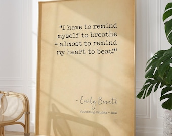 Op de afbeelding: Een rechthoekig ingelijst wandkunstwerk met een lichtbruine achtergrond en de zwarte tekst: I have to remind myself to breathe - almost to remind my heart to beat! - Emily Bronte, Wuthering Heights - 1847 in een typemachinelettertype.