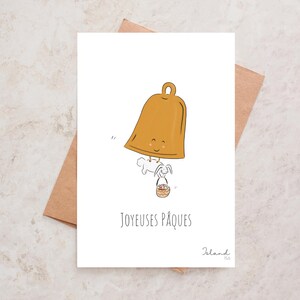 Carte “Joyeuses Pâques” avec le lapin de Pâques et une cloche qui distribuent les chocolats