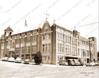 Może przedstawiać: Czarno-białe zdjęcie dużego budynku z tabliczką z napisem "The Historic District". Budynek ma dużą, ozdobną fasadę z wieżą zegarową. Zdjęcie zostało zrobione w Columbus, Georgia, w 1958 roku.