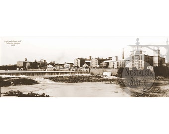 Może przedstawiać: Czarno-białe zdjęcie dużego kompleksu przemysłowego z tamą i rzeką na pierwszym planie. Tekst "Eagle and Phenix Mill Columbus, Georgia 1931" jest widoczny w lewym górnym rogu obrazu.