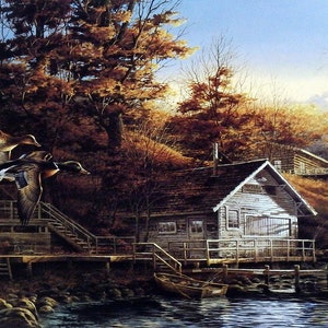 May include: A rustic wooden cabin with a porch overlooking a lake. Two ducks fly in the air above the cabin. The trees are in autumn colors, with shades of red, orange, and yellow.