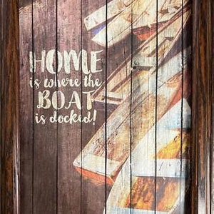 May include: A framed wood sign with a rustic wood background and the text "Home is where the boat is docked!" in white lettering. The sign features a stack of weathered wooden planks.