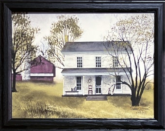 May include: A painting of a white farmhouse with a red barn in the background. The farmhouse has a porch with a rocking chair and a wreath on the door. The trees are bare and the grass is brown. The painting is framed in black.