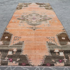 May include: A rectangular, vintage-style rug with a central medallion design. The rug features a warm color palette of peach, brown, and gray tones. The rug's dimensions are not visible in the image.