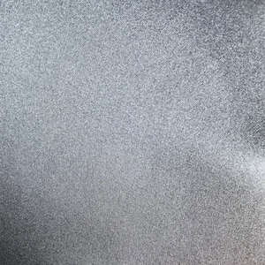 Puede incluir: Primer plano de una tela lisa plateada con un brillo sutil. La tela tiene un tejido fino y uniforme y una superficie ligeramente texturizada.